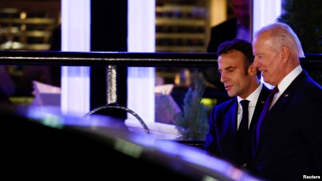 El presidente estadounidense Joe Biden y el presidente francés Emmanuel Macron caminan junto a un vehículo mientras se reúnen para cenar en el restaurante Fiola Mare en el barrio de Georgetown de Washington, 30 de noviembre de 2022. REUTERS/Evelyn Hockstein