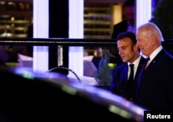 Predsjednik SAD DJoe Biden i predsjednik Francuske Emmanuel Macron hodaju pored vozila tokom sastanka u Washingtonu, 30. novembra 2022.