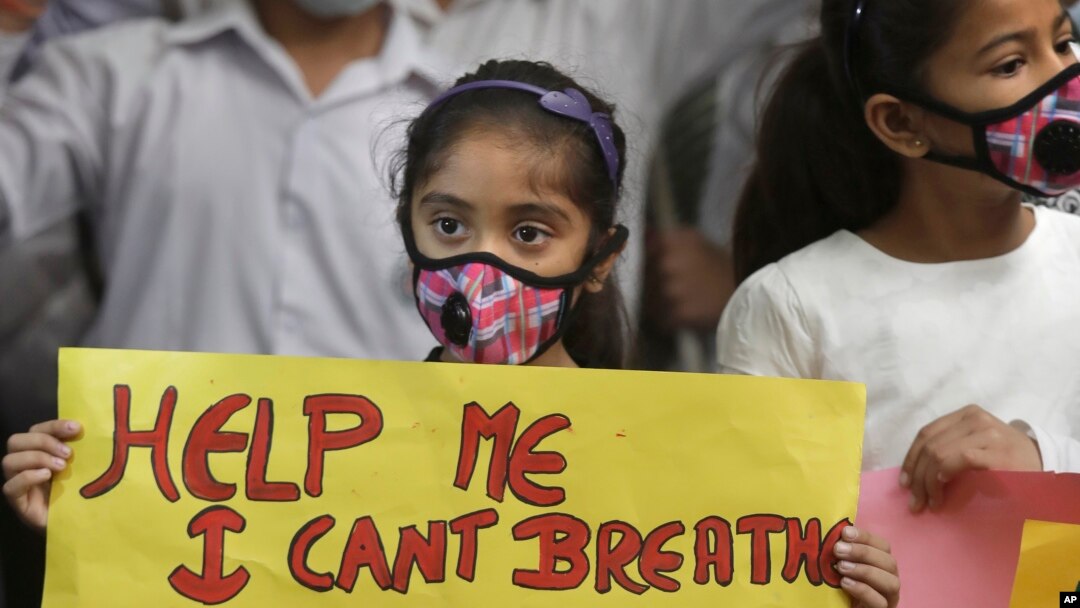 Seorang anak perempuan India memegang poster memprotes polusi udara di India, New Delhi, India, 6 November 2016. 