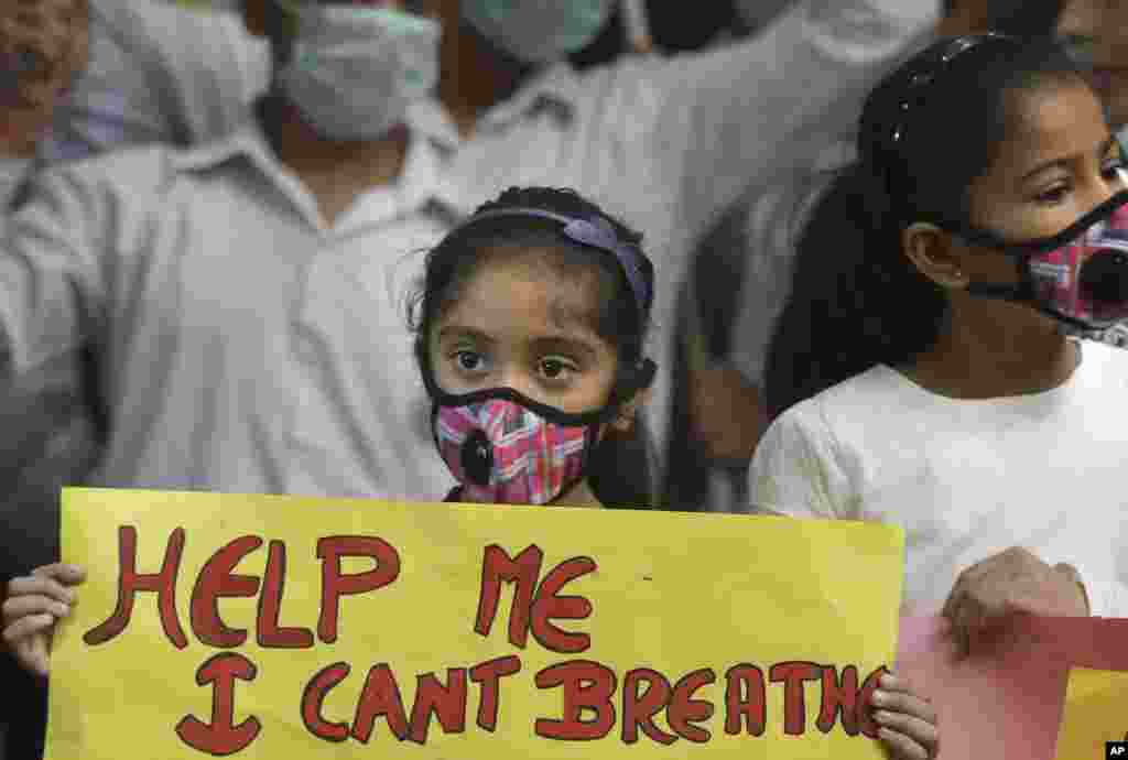 An Indian girls holds a banner during a protest against air pollution in New Delhi. The Delhi government ordered that all city schools be shut, construction activity halted and all roads be doused with water as crippling air pollution has engulfed the capital.