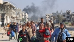 TOPSHOT - Palestinians displaced from shelters in Beit Hanoun cross the main Salaheddine road into Jabalia in the northern Gaza Strip following Israeli army evacuation orders on November 12, 2024, amid the ongoing war in the Palestinian territory between 