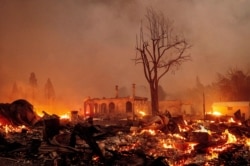 Buildings burn as the Dixie Fire tears through the Greenville community of Plumas County, California, Aug. 4, 2021.