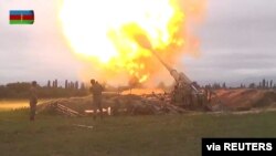 A still image from a video released by the Azerbaijan's Defense Ministry shows members of Azeri armed forces firing artillery during clashes between Armenia and Azerbaijan over the territory of Nagorno-Karabakh in an unidentified location.