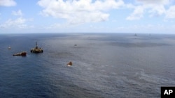 Handout picture released on November 21, 2011 by the Brazilian National Agency of Petroleum showing supply boats cleaning an oil spill around a Chevron platform operating in the Frade oil field in the Atlantic Ocean 120 km offshore Campos, northern state 