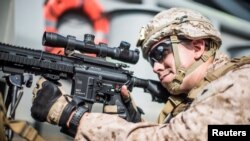 A U.S. Marine Corps rifleman with Kilo Company, Battalion Landing Team 3/5, provides security aboard the amphibious assault ship USS Boxer during its transit through Strait of Hormuz in Gulf of Oman, Arabian Sea, July 18, 2019. 