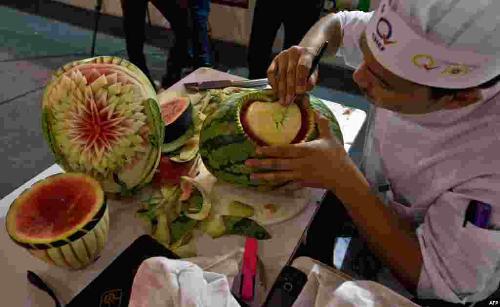 An Indian chef carves a watermelon during a fruit and vegetable carving compitition at &#39;Culinary Art India 2014&#39; in New Delhi. 250 chefs come together, under one roof to show-off their culinary skills.