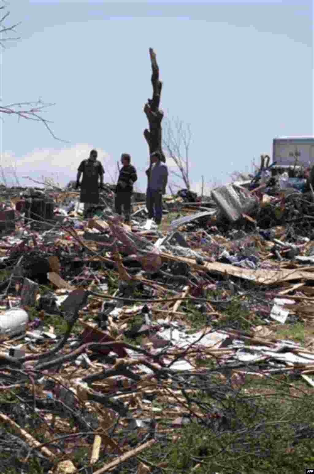 Tim Heath, left, and his cousin, who did not want to give their names, look through what is left of his home, Thursday, April 28, 2011, in Phil Campbell, Ala. Wednesday's tornado destroyed his home and his grandmother's house across the street. (AP Photo/