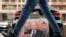 A placard featuring an image of Russian President Vladimir Putin and reading "We are with him for the sovereignty of Russia! And you?" is seen left in front of the Russian State Duma building in central Moscow.