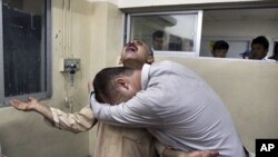 Pakistanis mourn over the death of their relative killed in a firing incident, at a local hospital in Quetta, Pakistan, October 4, 2011.