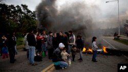 People whose homes were flooded after heavy rain protest with a burning road block in Lujan, Argentina, Aug. 11, 2015. 