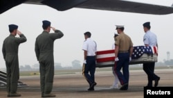 FILE - Pilots salute as U.S. soldiers carry a casket containing human remains, believed to belong to a U.S. servicemen missing in action during the Vietnam War, during a repatriation ceremony at Noi Bai airport in Hanoi, November 2012.