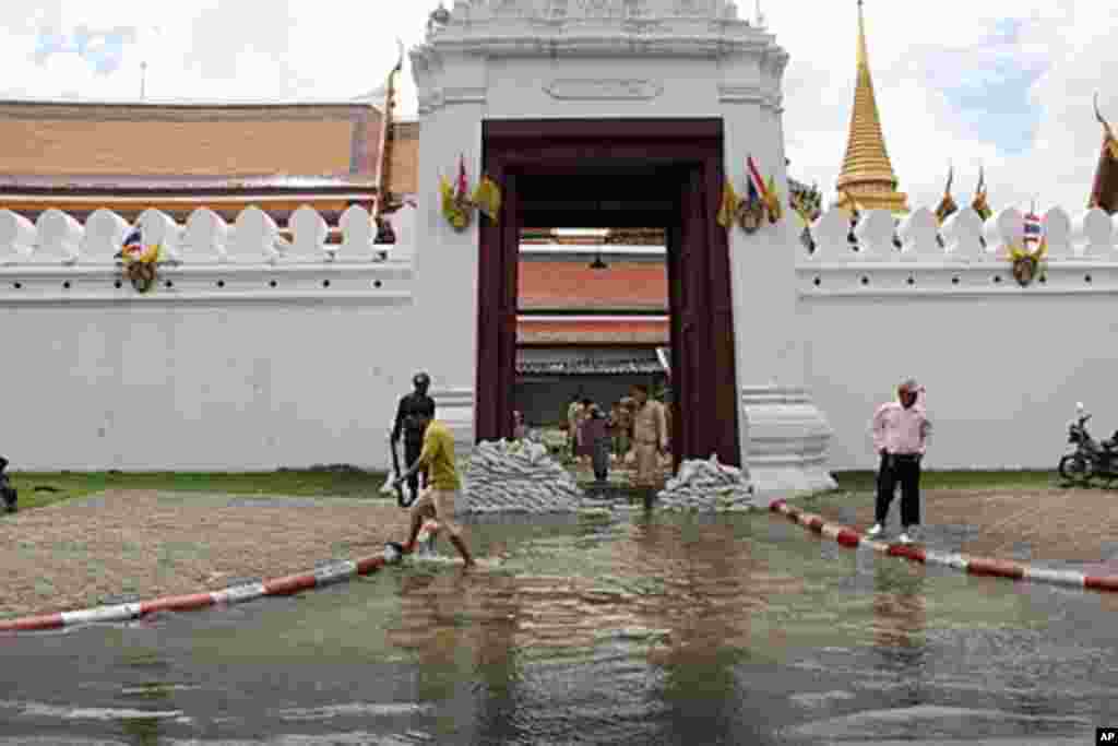 Wat Phra Kaew, the complex of temples is a popular tourist attraction. Military personnel set up flood barriers and pumps to drain water from the flooded entrance during high tide, Bangkok, Thailand, October 28, 2011. (VOA)