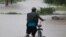 Un hombre camina con su bicicleta a través de inundaciones hasta las rodillas en un vecindario de Jehova, Honduras, el miércoles 4 de noviembre de 2020. Eta se debilitó de huracán de categoría 4 a tormenta tropical.