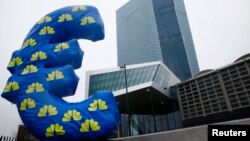 FILE - An inflated euro sign is seen outside the new headquarters of the European Central Bank (ECB) in Frankfurt, Jan. 22, 2015. 