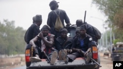 Vigilantes and local hunters armed with locally made guns patrol on the street near the Independent National Electoral Commission office in Yola, Nigeria, Feb. 25, 2019.