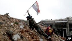 叙利亚军队的士兵在山顶上插上叙利亚国旗(2016年12月5日)