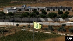 A Hezbollah flag flies in the Lebanon village of Aitaroun, near the northern Israeli town of Avivim, Aug. 26, 2019. 