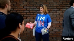 FILE - A woman campaigns in London, May 20, 2016, for Britain to stay in the European Union. The WTO’s leader warns that a June 23 vote supporting Brexit could harm Britain’s economy. (REUTERS/Kevin Coombs)