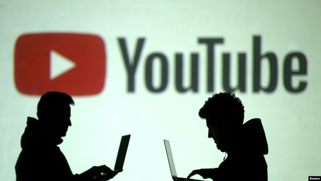 Siluet pengguna perangkat seluler terlihat di sebelah proyeksi layar logo Youtube pada ilustrasi gambar ini yang diambil 28 Maret 2018. (Foto: Reuters/Dado Ruvic)