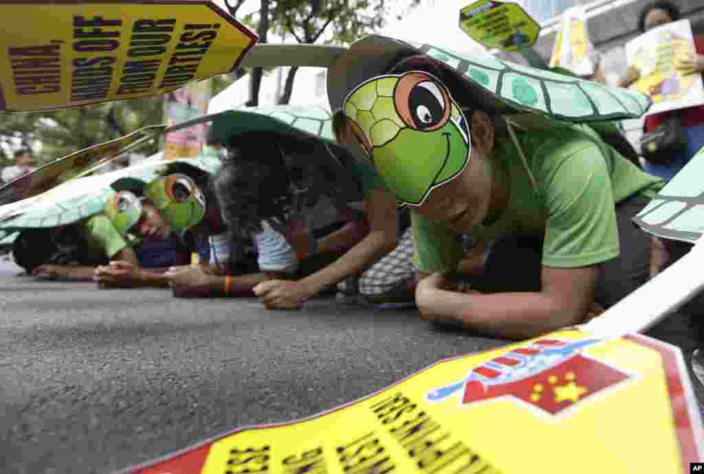 Protesters, wearing green sea turtle costumes, picket the Chinese consulate at the financial district of Makati city, Philippines, May 16, 2014.