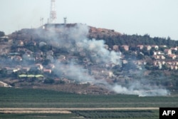 Asap mengepul di kota Metulla di utara Israel dari roket lintas batas yang diluncurkan dari sisi Lebanon pada 26 Juni 2024. (Foto: AFP)