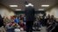 People look on as Democratic presidential candidate Sen. Bernie Sanders of Vermont speaks during a meeting with volunteers at a canvass lunch at Wartburg College in Waverly, Iowa, Jan. 30, 2016. 