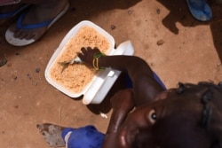 A child, who fled with others from his village in northern Burkina Faso following attacks by assailants, eats inside a school on the outskirts of Ouagadougou, Burkina Faso, June 15, 2019.