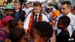 France's President Emmanuel Macron speaks with children during his visit at the Kavani district in Mamoudzou, on the French Indian Ocean territory of Mayotte on Dec. 19, 2024, following the Cyclone Chido's passage over the archipelago.