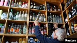 Mustafa Demirci arranges bottles of alcoholic beverages at his liquor shop ahead of a nationwide "full closure" amid the spread of the coronavirus, in Ankara, Turkey, April 28, 2021. 