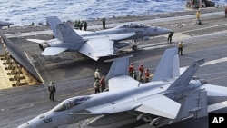 FA-18 air fighters prepare to take off on the U.S. carrier George Washington in the Pacific near Minamidaito Island in Okinawa Prefecture, southern Japan, during a joint drill with the Japanese Self-Defense Forces, FILE December 9, 2010.