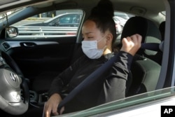 Instacart worker Saori Okawa adjusts her seatbelt on her way to deliver groceries on Wednesday, July 1, 2020, in San Leandro, Calif.