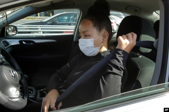 Instacart worker Saori Okawa adjusts her seatbelt on her way to deliver groceries on Wednesday, July 1, 2020, in San Leandro, Calif.