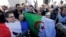 Muslims, holding French and Algerian flags, attend a gathering in front of the Paris Mosque after Friday prayers September 26, 2014, to pay tribute to Herve Gourdel, a French mountain guide who was beheaded by an Algerian Islamist group.