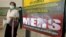A woman wearing a mask walks past an information banner on Middle East Respiratory Syndrome (MERS) at the entrance of Bamrasnaradura Infectious Diseases Institute on the outskirts of Bangkok, Thailand, June 19, 2015. 