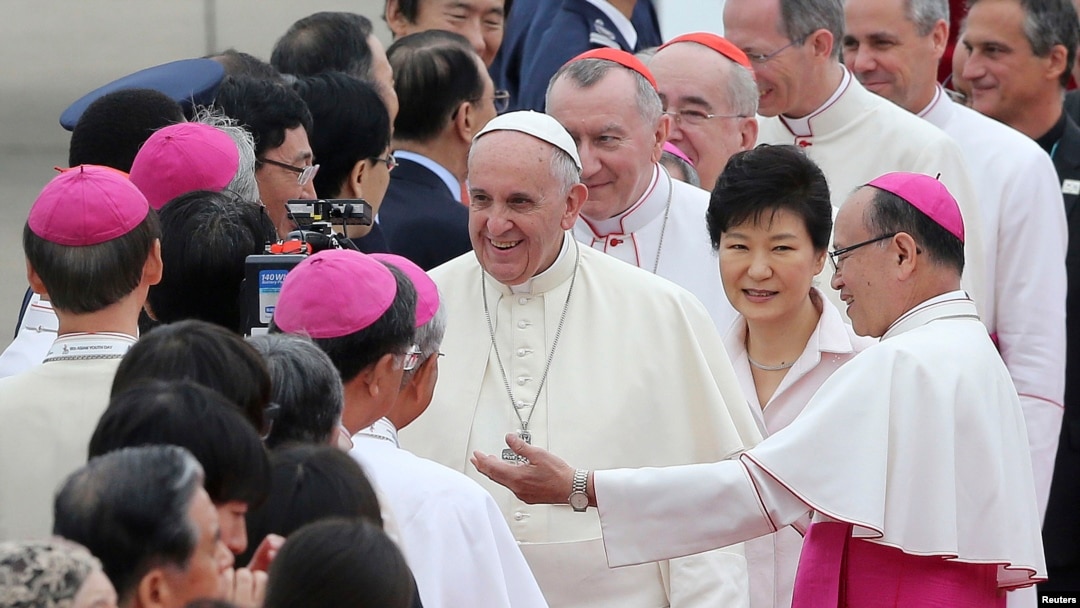 Paus Fransiskus (tengah) mendapat sambutan hangat sambil diapit oleh Presiden Korea Selatan Park Geun-hye (kedua kiri) ketika tiba di Pangkalan Udara Seoul di Seongnam, 14 Agustus 2014.