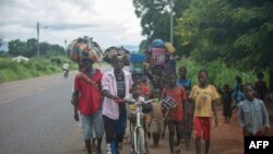 FILE —Displaced people from the province of Cabo Delgado walk through the streets of Namapa, Erati district of Nampula, Mozambique on February 27, 2024.