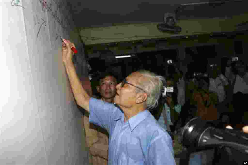 Myanmar journalist Win Tin signs a white board at National League for Democracy Party, the party of detained pro-democracy leader Aung San Suu Kyi, in Yangon, Myanmar, Thursday, Feb. 12, 2009, demanding her release during ceremonies to mark the 62nd anniv