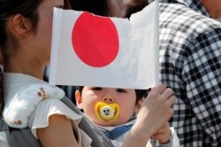 일본 도쿄의 황국 앞에서 성조기를 쥔 아기. (자료사진)