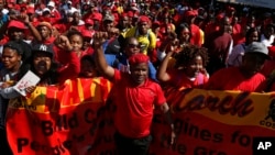 Des ouvriers marchent pour le 1er mai devant le bâtiment du Stock Exchange de Johannesburg, le 1er mai 2017.