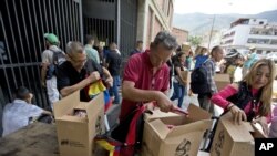 Empleados de un centro cultural de Venezuela apoyado por el gobierno en disputa de Nicolás Maduro reciben cajas con alimentos subsidiados distribuidos bajo el programa CLAP. Caracas, Venezuela, julio 6 de 2018. AP/Fernando Llano.