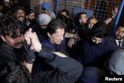 Pakistan's former PM, Imran Khan, along with his supporters walks at the district High Court in Lahore