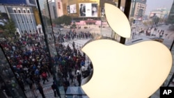 FILE - People line up to enter a newly opened Apple Store in Wangfujing shopping district in Beijing, Oct. 20, 2012.