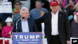 FILE - Then-Republican presidential candidate Donald Trump (R) stands next to Senator Jeff Sessions during a rally in Madison, Alabama, Feb. 28, 2016. Sharing the senator's views on illegal immigration, Trump tapped Sessions for attorney general.