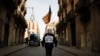 A man wearing a Guy Fawkes mask holds an Estelada, a Catalan pro-independence flag, as he walks towards a protest against a separatism-related police operation, in Barcelona, Spain, Oct. 28, 2020. His signs oreads "Enough repression. Independence."