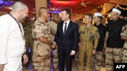 French President Emmanuel Macron (C) greets soldiers as he attends a Christmas dinner with some 700 French soldiers of France's Barkhane anti-jihadist force at the French air hub base for the Barkhane force in Niamey, Niger, Dec. 22, 2017.