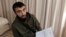 FILE - Chechen blogger Tumso Abdurakhmanov holds a letter from Interpol during an interview with The Associated Press somewhere in Poland, Nov. 14, 2018.