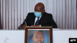 Agathon Rwasa, the head of the National Council for Freedom (CNL), Burundi's main opposition party, wears a face mask as he signs the book of condolences at the state house in Bujumbura, June 12, 2020.