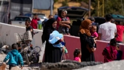 Orang-orang membopong anak-anak mereka untuk menyeberang ke Suriah dengan berjalan kaki dari timur Lembah Bekaa, Lebanon, Sabtu, 5 Oktober 2024. (Foto: Hassan Ammar/AP Photo)