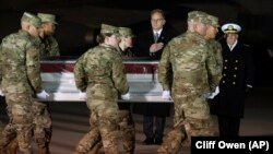 Acting Navy Secretary Thomas Modly, center, and Navy Admiral Michael Gilday, Chief of Naval Operations, right, look on as an Air Force carry team moves the transfer case containing the remains of Navy Seaman Apprentice Cameron Scott Walters, Dec. 8, 2019. (AP Photo/Cliff Owen)