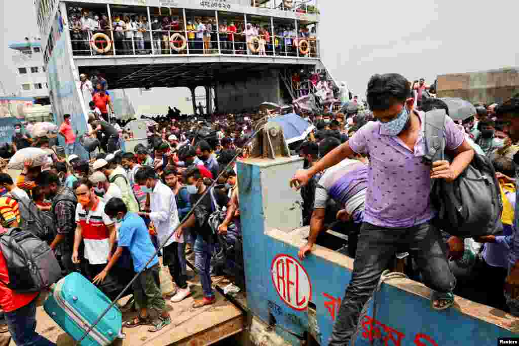 Migrant people and workers get off an overcrowded ferry at Mawa ferry terminal in Munshiganj, Bangladesh, as they are returning to the capital city after government has decided to reopen exports industries including garment factories.